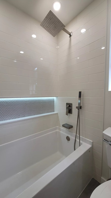 A picture of a white bathtub, with a dark brown towel rack next to it.